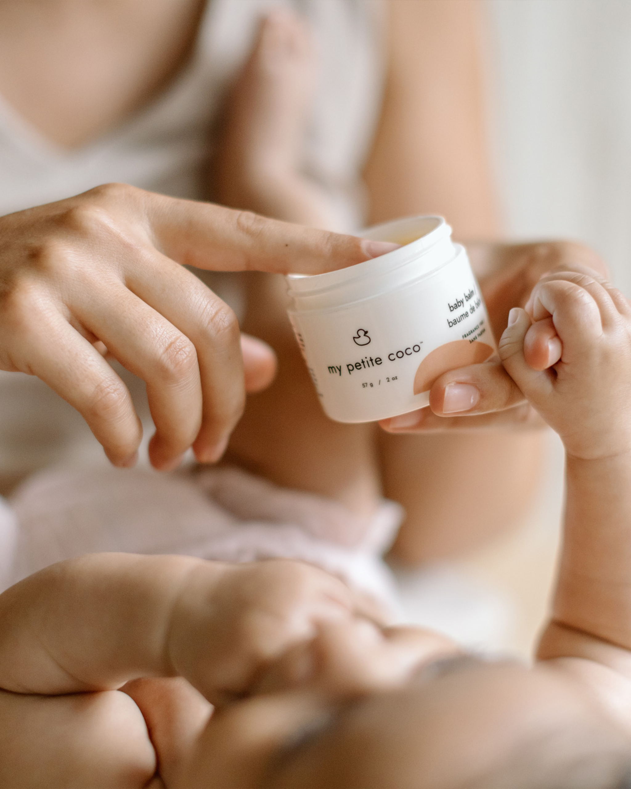 Mom applying My Petite Coco baby balm to soothe dry baby skin.